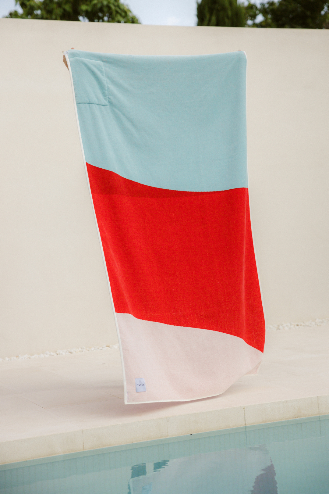 Berry beach towel. An extra large beach towel, extra soft texture as it is made og 100% organic cotton. Beautyful design with blue, red and white colors. Picture of the beach towel in a swimingpool.