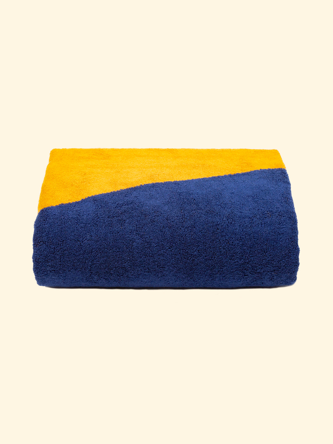 Model "Dune" of Tucca beach towel 100% organic cotton, perfectly folded as presented on the packaging, with two pins on each side, the ones that can be used to fix your beach towel to the sand.