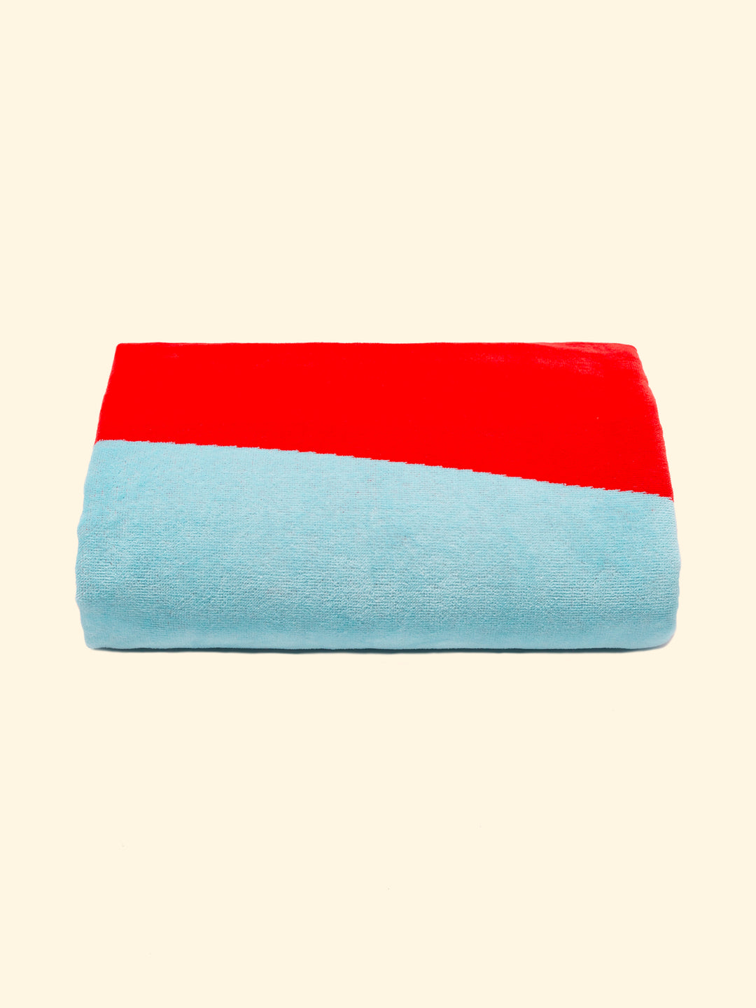 Model Berry of Tucca beach towel perfectly folded as presented on the packaging, with two pins on each side, the ones that can be used to fix your beach towel to the sand.