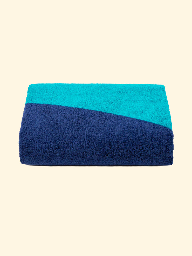 Model “Swell” of Tucca beach towel 100% organic cotton,perfectly folded as presented on the packaging, with two pins on each side, the ones that can be used to fix your beach towel to the sand.