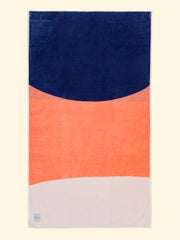 Tucca "Konoh" beach towel extended. Dark blue, creamy pink and white colors in big blocks composing a beautiful design. Large beach towel that doesn't get blown by the wind. Super soft texture as it is made with 100% organic cotton.